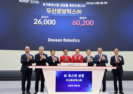 ▲두산로보틱스 박인원 대표(왼쪽 넷째), 류정훈 대표(왼쪽 다섯째)가 매매개시 벨을 누른 후 관계자들과 기념사진을 촬영하고 있다.